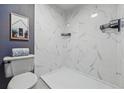 Modern bathroom features white marble-style tiling, a sleek shower, and updated fixtures at 9917 Grove Way # A, Westminster, CO 80031