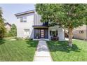 Contemporary home featuring a manicured lawn and a walkway leading to a modern front door, framed by a mature tree at 2048 Meade St, Denver, CO 80211