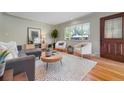 Bright living room features hardwood floors, modern furniture, and a large window at 3245 S High St, Englewood, CO 80113