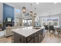 Modern kitchen with quartz counters, stainless steel appliances, and an open concept layout to the dining and living area at 624 Simmental Loop, Castle Rock, CO 80104