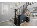 Elegant staircase with dark wood banister, neutral carpet, and stylish decor at 624 Simmental Loop, Castle Rock, CO 80104