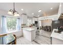 Bright kitchen with white cabinetry, marbled countertops, and stainless steel appliances, flowing into the dining area at 3679 S Zeno Way, Aurora, CO 80013