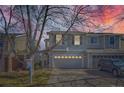 Charming two-story home with gray siding, a two-car garage, under a colorful sunset at 9380 Jackson St, Thornton, CO 80229