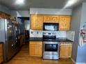 Kitchen with wood cabinetry, stainless steel appliances, and light countertops at 5129 Chandler Way, Denver, CO 80239