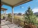 A shaded back porch with decorative hanging ornament faces outward toward a grassy area at 16406 W 85Th Ln # A, Arvada, CO 80007
