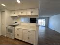 Bright kitchen featuring white cabinetry and modern appliances overlooking the living area at 943 S Zeno Way # 205, Aurora, CO 80017