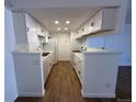 Spacious kitchen with white cabinetry, marble countertops, and modern appliances at 943 S Zeno Way # 205, Aurora, CO 80017