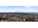 Expansive aerial view of a sprawling neighborhood with mountain views and winding roads at 3234 Picketwire Way, Castle Rock, CO 80108