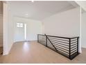 Modern home entryway featuring light hardwood floors and a metal handrail at 366 Agoseris Way, Castle Rock, CO 80104