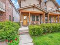 Inviting home exterior features a manicured lawn, lush green bushes, and a charming front porch with rocking chairs at 383 S Franklin St, Denver, CO 80209