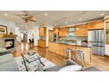 Open kitchen with stainless steel appliances, wood cabinets, granite countertops, and breakfast bar seating for casual dining at 383 S Franklin St, Denver, CO 80209