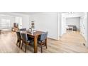 Inviting dining room features a wooden table with seating for six, light hardwood floors and ample natural light at 7193 S Newport Way, Centennial, CO 80112