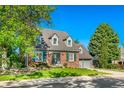 Beautiful two-story brick home featuring green shutters, dormer windows and a well manicured lawn at 7193 S Newport Way, Centennial, CO 80112