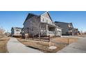 Two-story house with gray siding, covered porch, and a wooden fence at 13267 E 108Th Ave, Commerce City, CO 80022