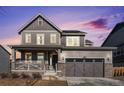 Two-story house with gray siding, attached garage, and a charming front porch at 13267 E 108Th Ave, Commerce City, CO 80022