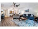 Bright living room boasts a modern ceiling fan, plush seating, and hardwood flooring at 7250 Eastmoor Dr # 122, Denver, CO 80237