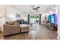 Open living area showcases hardwood floors, ample seating, and sliding glass doors to the backyard at 7250 Eastmoor Dr # 122, Denver, CO 80237