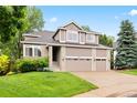 Two-story home with a three-car garage, brick accents, and a well-manicured lawn at 9871 Indian Wells Dr, Lone Tree, CO 80124