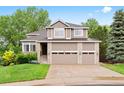 Two-story home with a three-car garage, brick accents, and a well-manicured lawn at 9871 Indian Wells Dr, Lone Tree, CO 80124