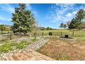 This backyard offers a fire pit, green grass, a garden, and a wooden deck at 15740 Sandtrap Way, Morrison, CO 80465