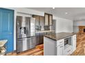 Modern kitchen featuring stainless steel appliances, granite countertops, island, and hardwood floors at 15740 Sandtrap Way, Morrison, CO 80465