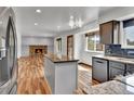 Cozy open-concept living room with hardwood floors and a stone fireplace at 15740 Sandtrap Way, Morrison, CO 80465
