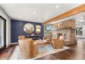 Cozy living room with leather armchairs, wood flooring, and a stone fireplace at 23785 Currant Dr, Golden, CO 80401
