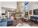 Living room featuring a stone fireplace, wood floors, and large windows offering natural light at 23785 Currant Dr, Golden, CO 80401