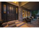 Inviting front porch boasts brick accents, a cozy seating area, decorative front door and a 'thankful to be together' door mat at 7954 S Franklin Ct, Centennial, CO 80122