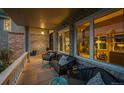 Cozy covered front porch with comfortable seating, brick detailing, and view into large windows of the front room at 7954 S Franklin Ct, Centennial, CO 80122