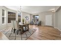 Dining room with hardwood flooring, modern rug, and ample natural light at 16404 E 117Th Ave, Commerce City, CO 80022