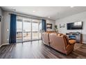 Bright living room featuring hardwood floors, recessed lighting, and a sliding glass door to outdoor space at 4128 Castle Vista Ln, Castle Rock, CO 80104