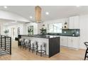 Bright, updated kitchen featuring a large island with bar seating, modern fixtures, and stainless appliances at 7382 W Stanford Ave, Littleton, CO 80123