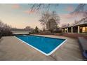 Sparkling in-ground pool with concrete surround and mature landscaping, perfect for summer fun at 7382 W Stanford Ave, Littleton, CO 80123