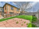 Spacious backyard with a brick patio area and lush grass, perfect for outdoor relaxation and activities at 1658 Winona Ct, Denver, CO 80204