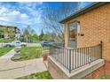 Close-up of the charming brick home's front porch with wrought iron railing and inviting entry at 1658 Winona Ct, Denver, CO 80204