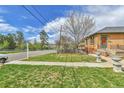 Well-maintained front yard with healthy green grass, landscaping, and a sidewalk leading to the home at 1658 Winona Ct, Denver, CO 80204