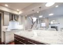 Bright kitchen featuring stainless appliances, granite countertops, a center island and stairs to the upper level at 2320 N Lafayette St, Denver, CO 80205