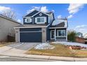 Stunning two-story home, navy blue exterior, two-car garage, and nicely landscaped yard at 9790 Moss Rose Cir, Highlands Ranch, CO 80129