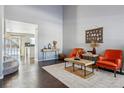 Bright living room with hardwood floors, two orange armchairs, and a wood coffee table at 9790 Moss Rose Cir, Highlands Ranch, CO 80129