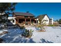 Modern farmhouse with covered porch, landscaping, and a snowy front yard at 11498 Evening Hunt Rd, Franktown, CO 80116