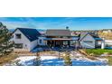 Modern farmhouse design with a welcoming covered porch and mountain views at 11498 Evening Hunt Rd, Franktown, CO 80116