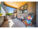 Cozy covered porch with wood-paneled walls, an adirondack chair, and a view of the house exterior at 2732 S Jackson St, Denver, CO 80210