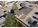 A bird's-eye view of the two-story brick apartment complex, surrounded by mature trees and parking spaces at 2241 Dexter Dr # 2, Longmont, CO 80501