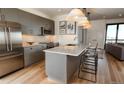 Modern kitchen with stainless steel appliances, a large island, and pendant lighting at 1643 Boulder St # 211, Denver, CO 80211