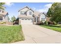 Attractive two-story home with a well-manicured lawn and a spacious driveway on a sunny day at 9294 Melborne Ct, Parker, CO 80134