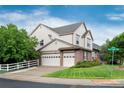 Angle view of the house with a three-car garage, a picket fence, and a green lawn at 2959 W 110Th Pl, Westminster, CO 80234