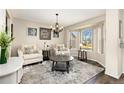 Bright living room featuring large windows, comfortable seating, and a decorative area rug at 6280 Snowberry Ave, Firestone, CO 80504