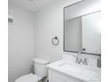 Well-lit half bathroom features modern fixtures, white vanity, and a sleek, black-framed mirror at 15045 E Louisiana Dr # B, Aurora, CO 80012