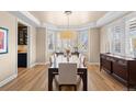 Dining room with hardwood floors, neutral paint, bay window, and a dark stained table with seating for eight at 6339 S Langdale Way, Aurora, CO 80016